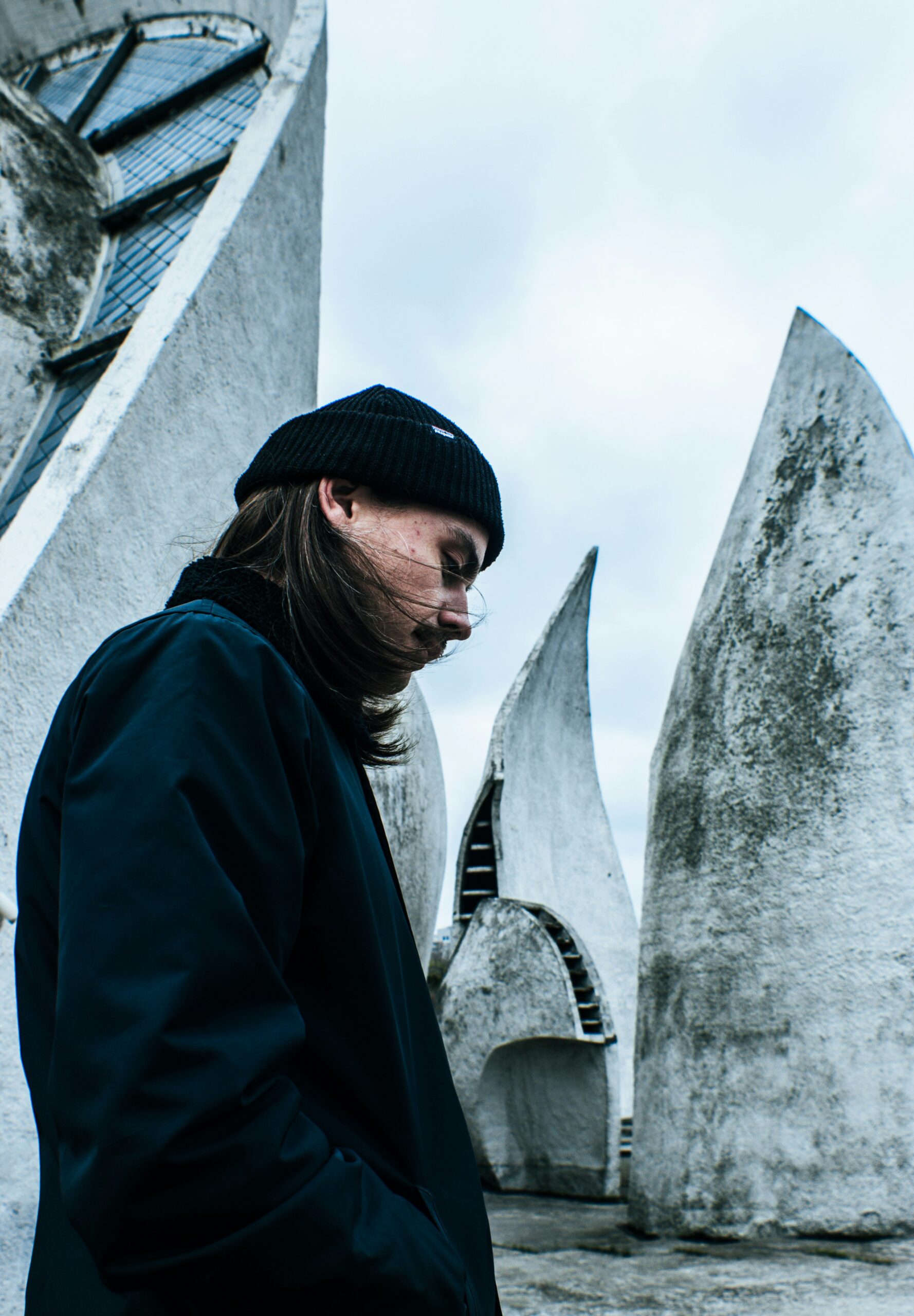 man standing and looking down near concrete wall